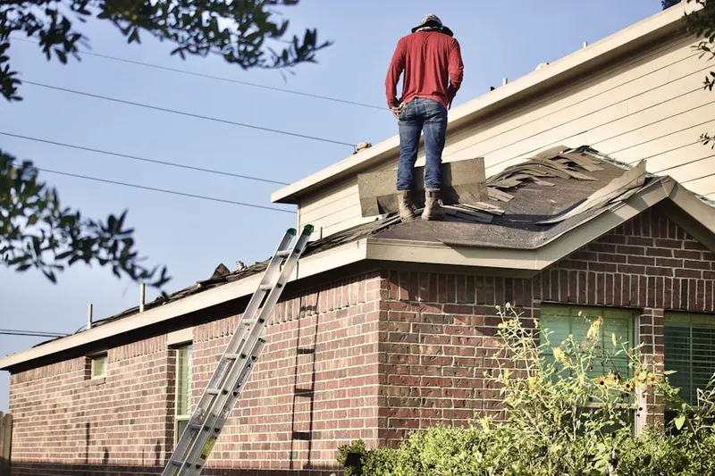Professional roofer working on a residential roof in West Bend